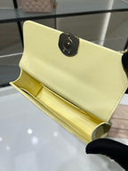 Chanel small crossbody bag with black circular turn-lock, light yellow leather interior