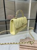 Quilted Chanel handbag with top handle and gold chain strap, light yellow leather