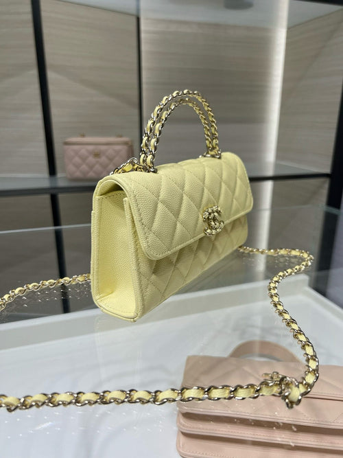 Quilted Chanel handbag with top handle and gold chain strap, light yellow leather