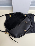 Black Celine crossbody bag with curved flap, gold hardware, and black strap