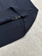 Navy polo shirt sleeve cuff detail with small metal embellishment