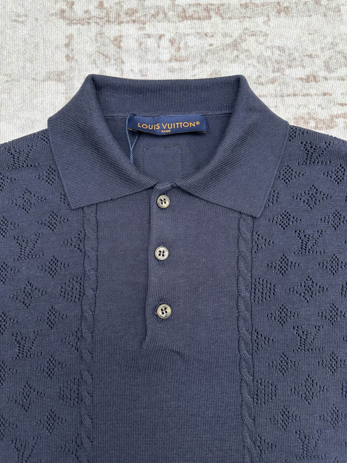 Navy polo shirt with open collar, three buttons, and neck brand label