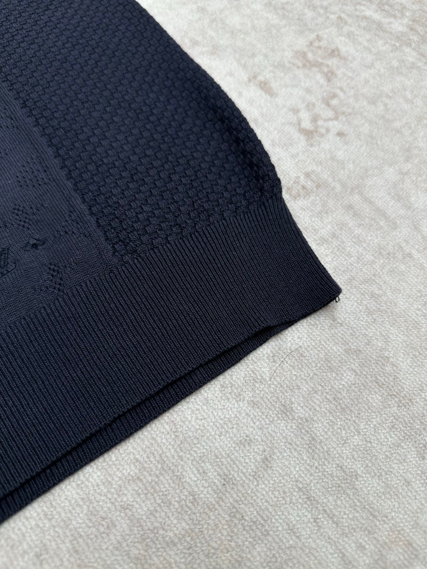 Navy knit polo sleeve hem with ribbed cuff and textured knit