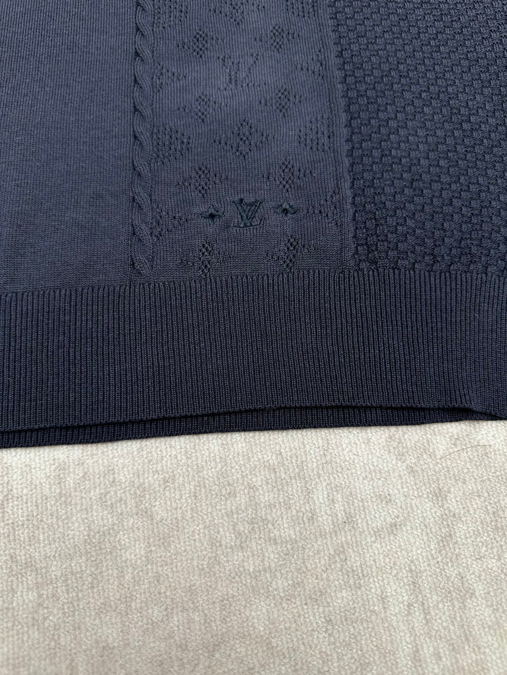 Navy knit polo fabric with textured pattern and ribbed hem band