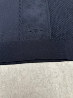 Navy knit polo fabric with textured pattern and ribbed hem band