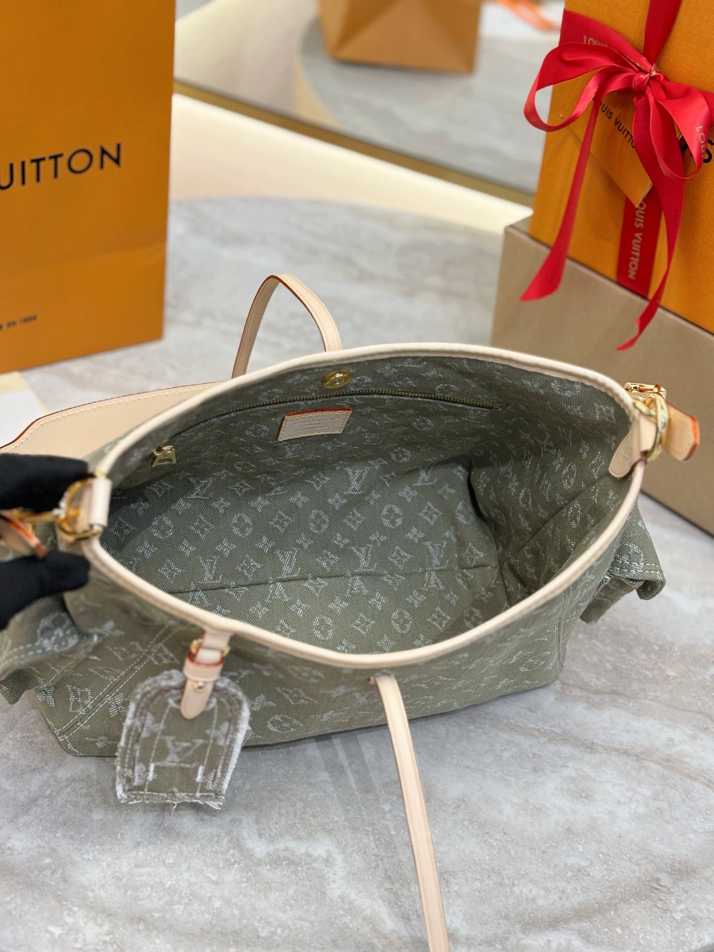 Louis Vuitton monogram shoulder bag interior, olive-gray canvas with tan leather trim.
