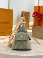 Louis Vuitton monogram mini bag, olive-gray canvas with tan handle and shoulder strap.