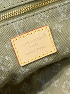 Louis Vuitton Paris label patch on olive-gray monogram canvas with tan border stitching.