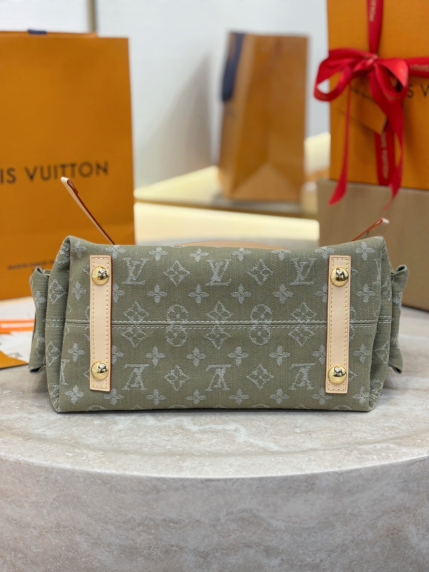 Louis Vuitton monogram satchel front, olive-gray with tan trim and gold hardware plaques.