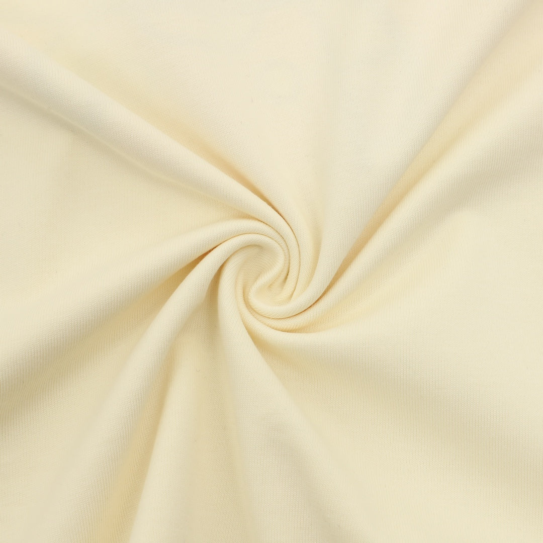Cream knit T-shirt fabric close-up with smooth texture