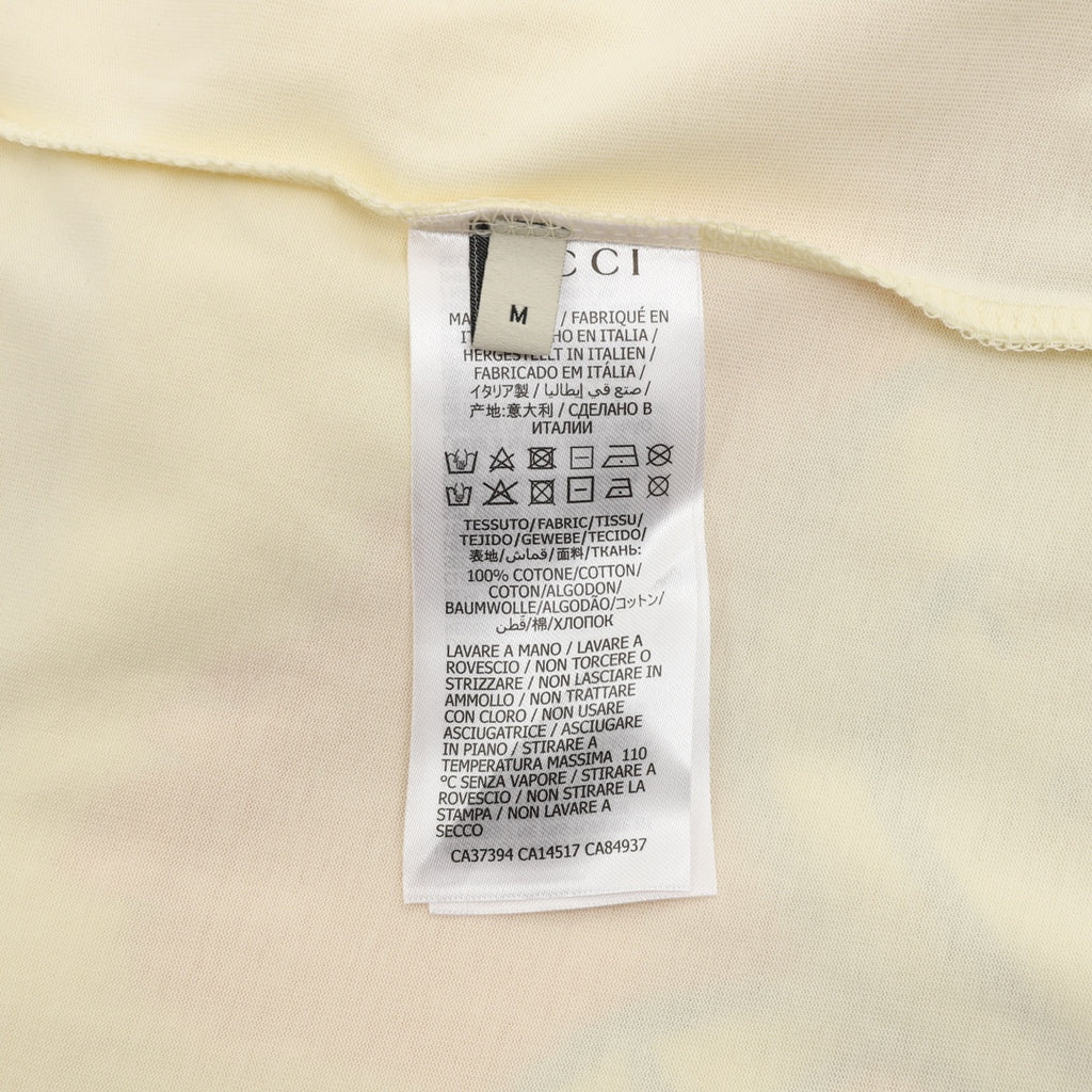 Cream T-shirt care label and size tag inside neckline