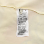 Cream T-shirt care label and size tag inside neckline