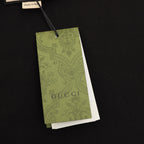 Black T-shirt with green Gucci hang tag attached