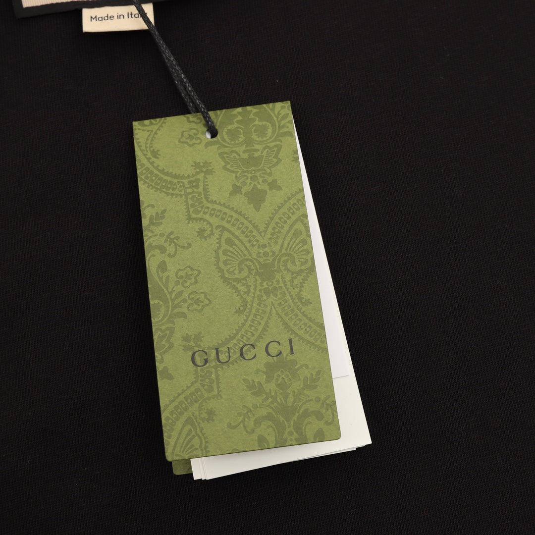 Black T-shirt with green Gucci hang tag attached