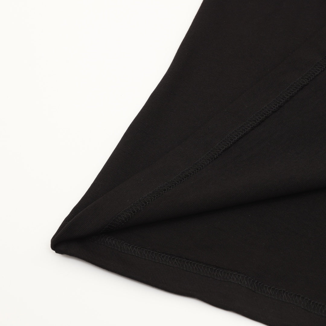 Black T-shirt hem and stitching detail on folded fabric