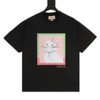 Black T-shirt with colorful cat face graphic on front and Gucci logo near hem
