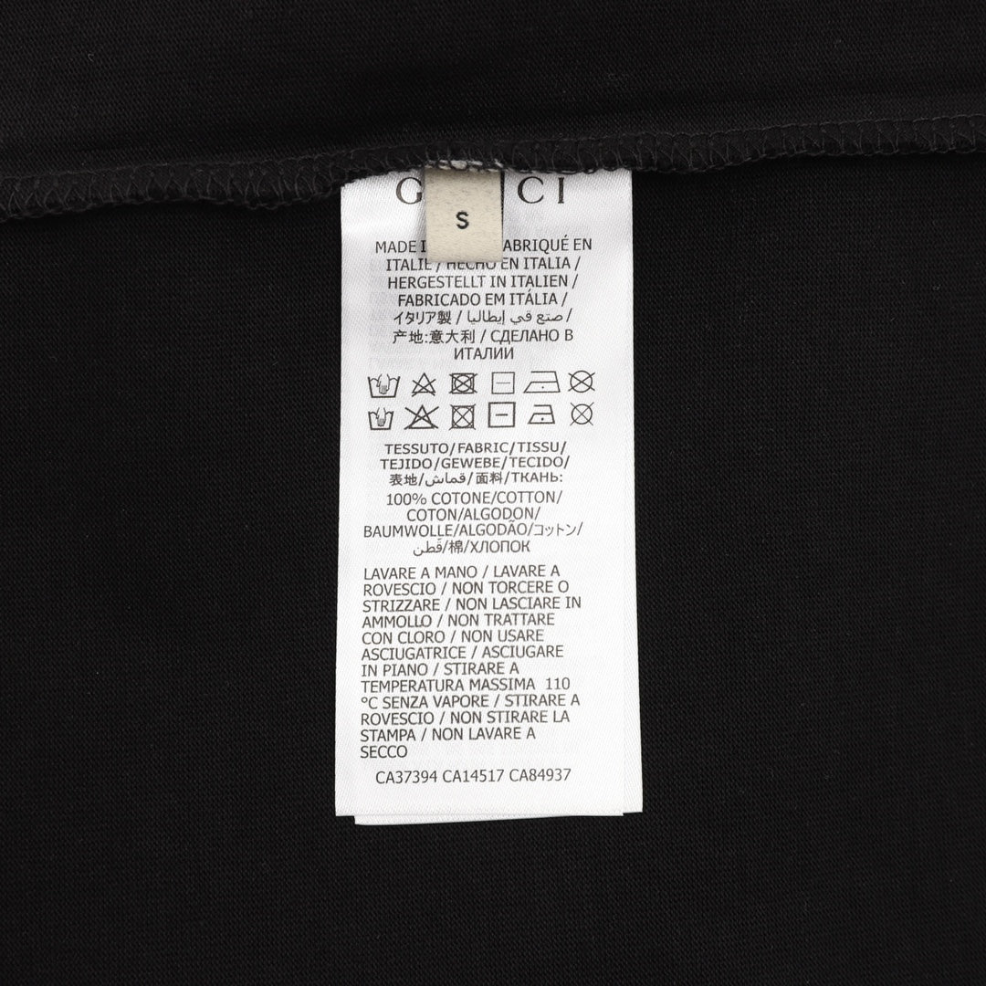 Black T-shirt care label near neck with printed Gucci branding