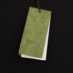 Black short-sleeve T-shirt with hanging green Gucci care tag