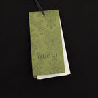 Black T-shirt with hanging green Gucci product tag