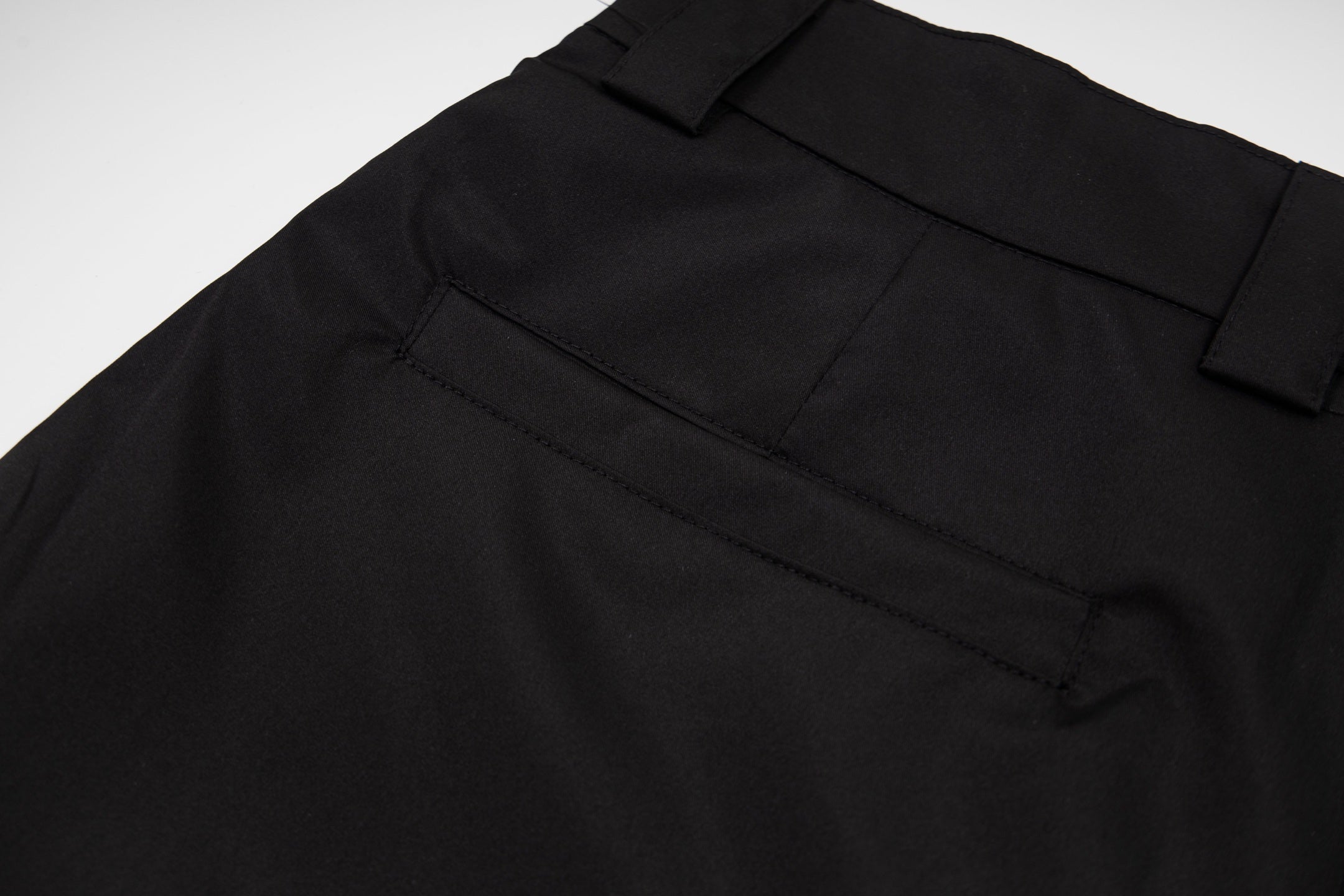 Black Prada dress pants close-up of waistband and side pocket seam