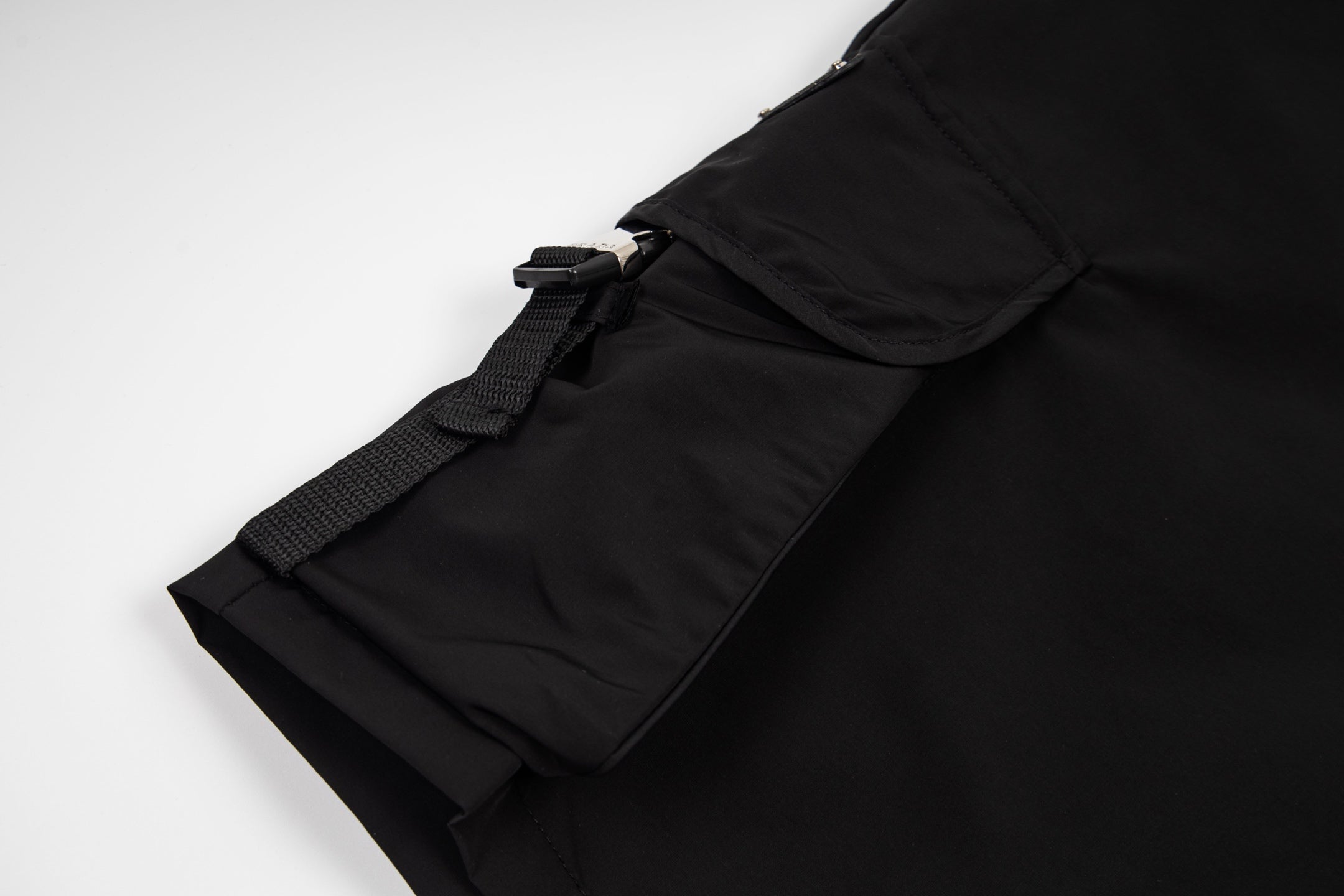 Black cargo shorts side pocket flap with strap and snap hardware