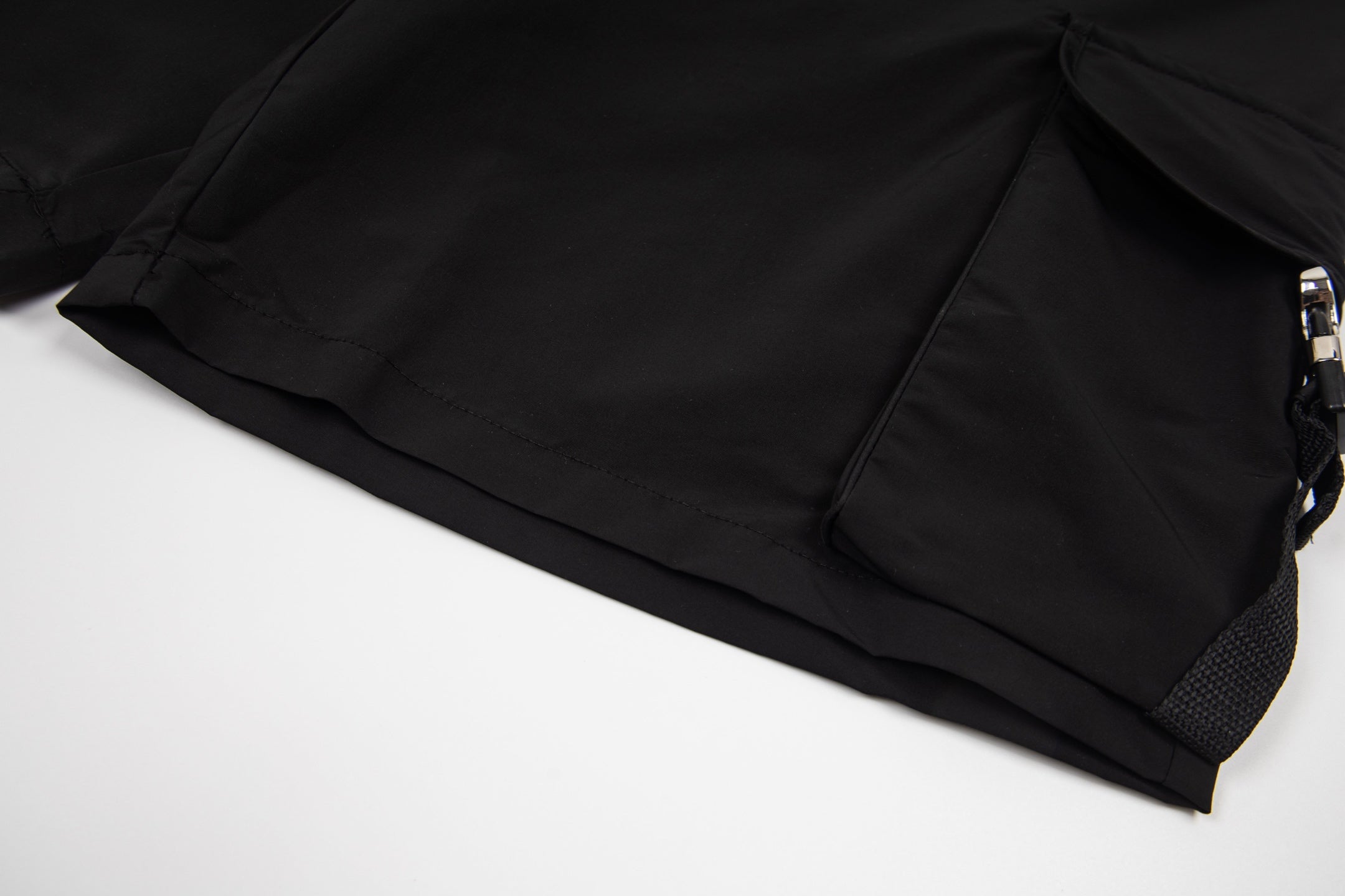 Black cargo shorts with side pocket flap and adjustable cord pull
