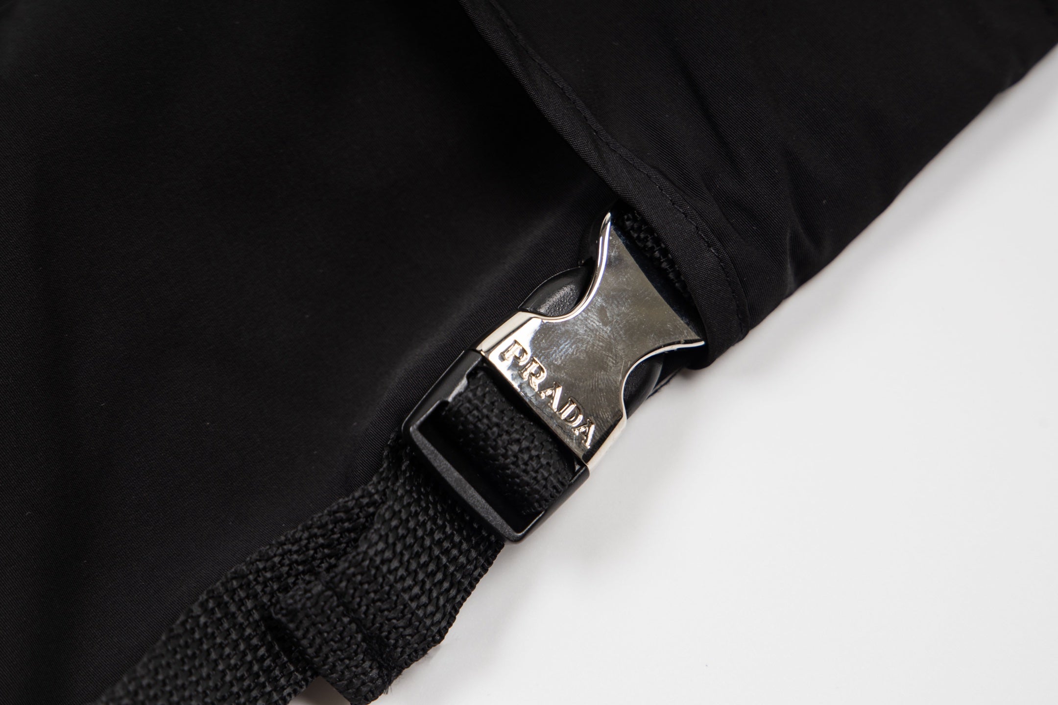 Black cargo shorts with metal logo buckle and woven strap
