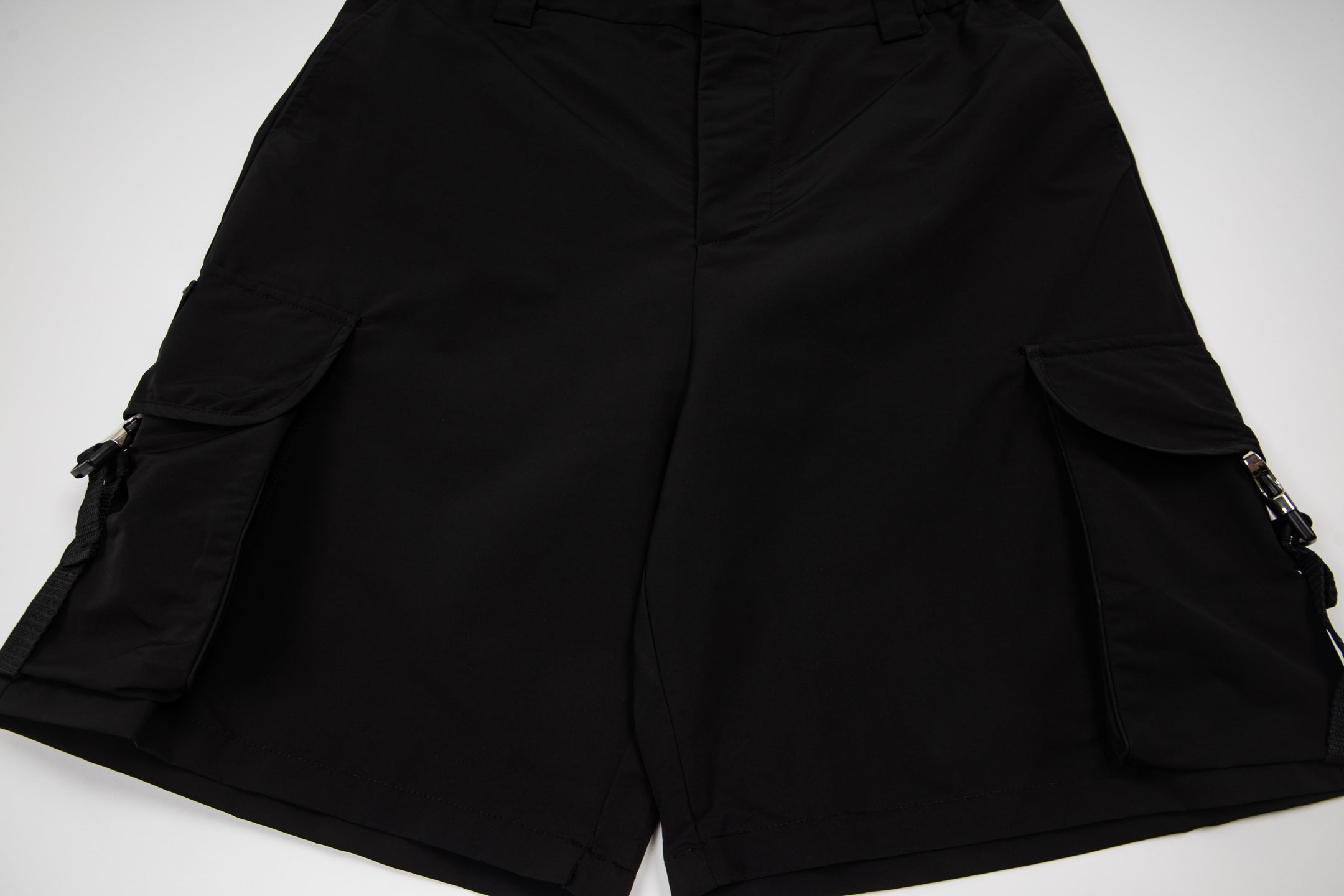 Black cargo shorts with central front seam and cargo side pockets