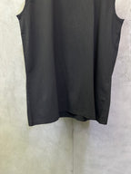 Dark sleeveless top with straight hem and crew neckline, side arm openings shown