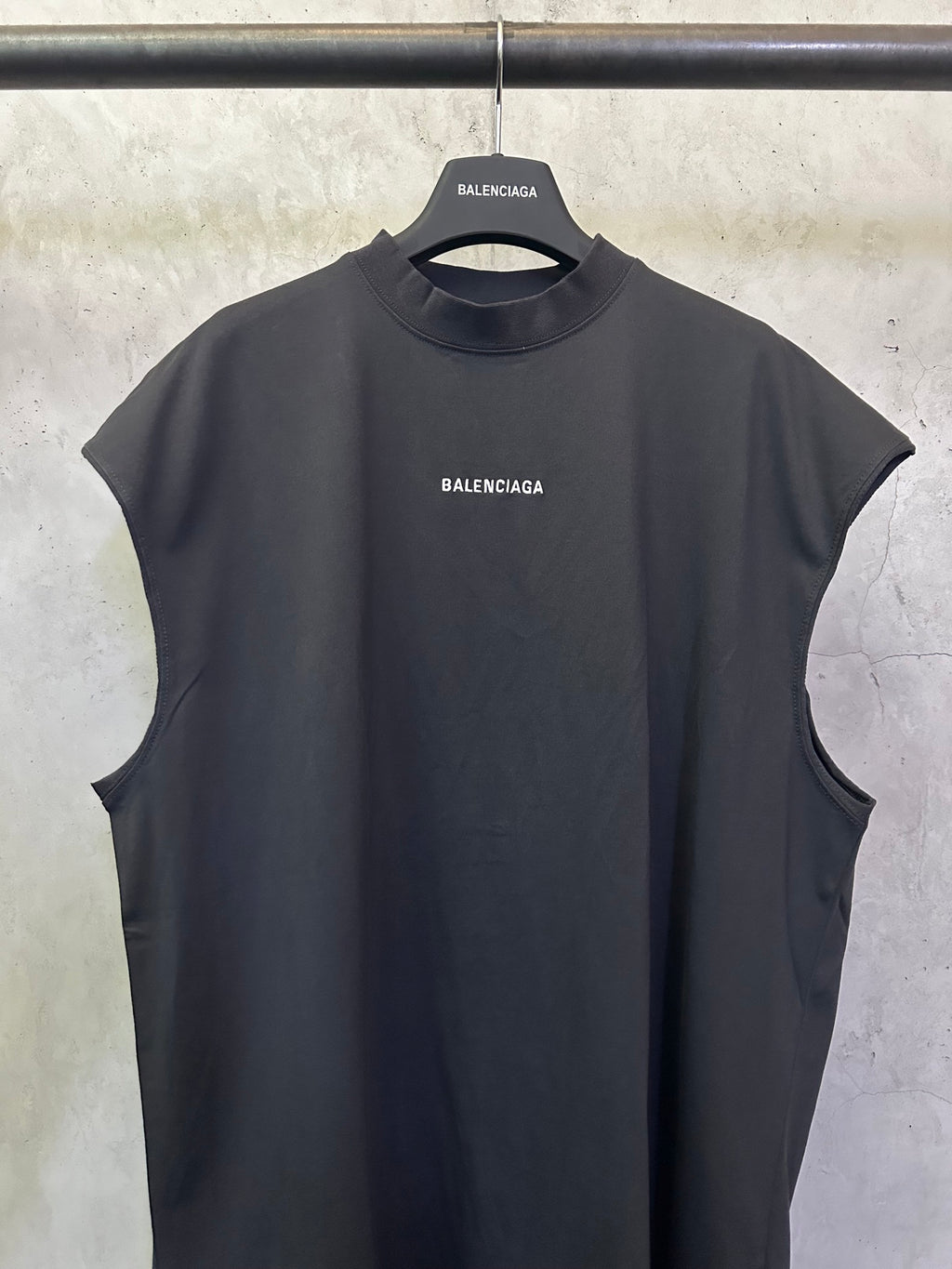 Sleeveless top in dark color with small chest logo and crew neck, sleeveless cut