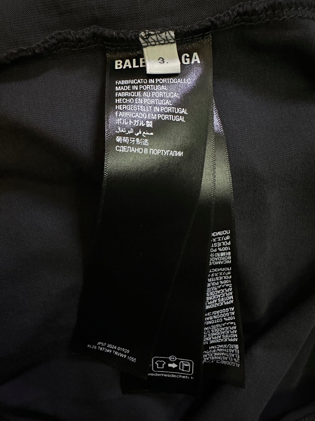 Interior neck and care label on black sleeveless top, with size and fabric details