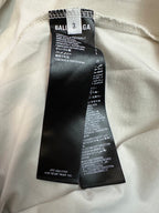 Clothing label inside collar on white T-shirt with care and fabric details