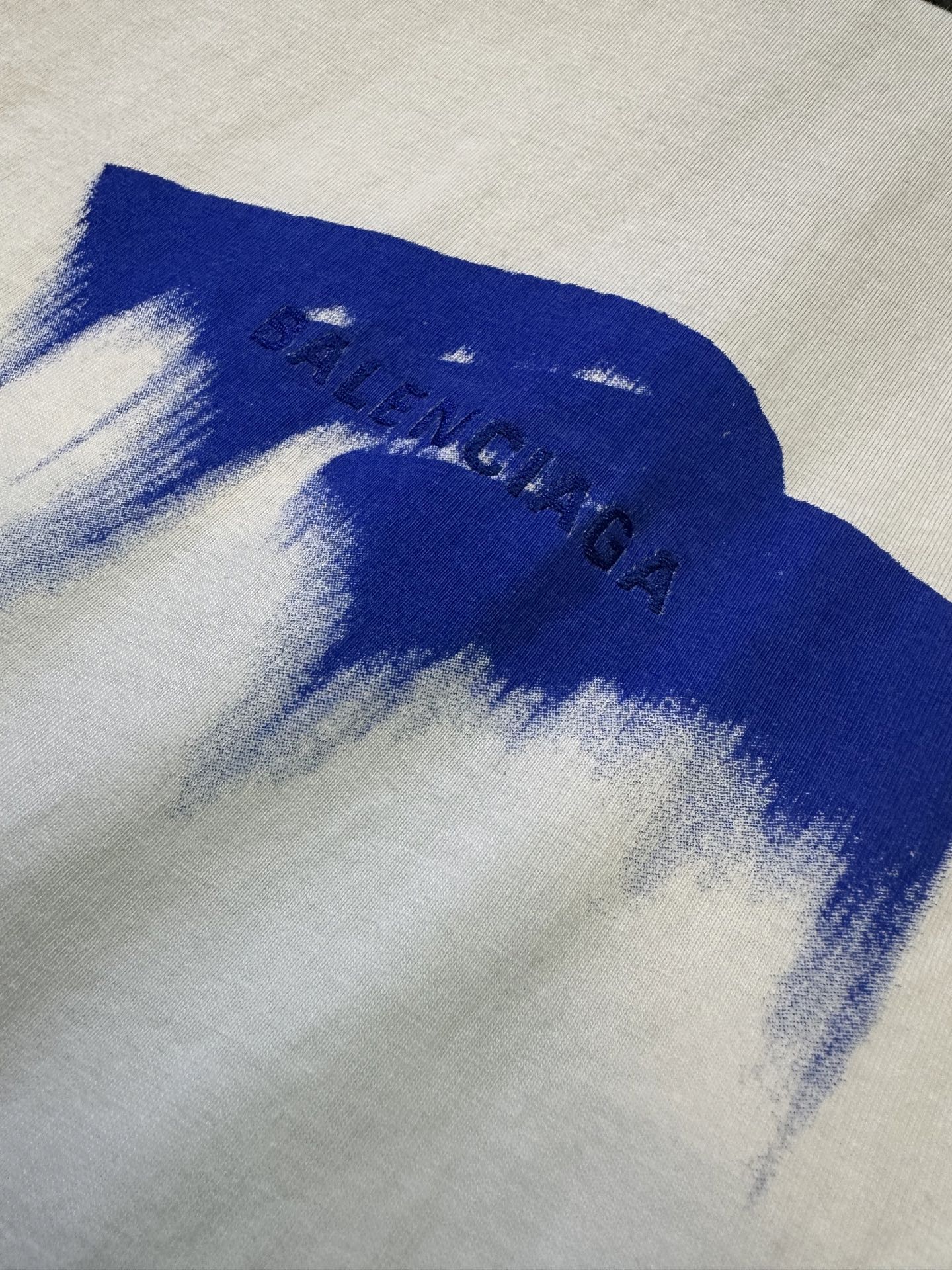 White T-shirt fabric with blue paint-style graphic and splatter