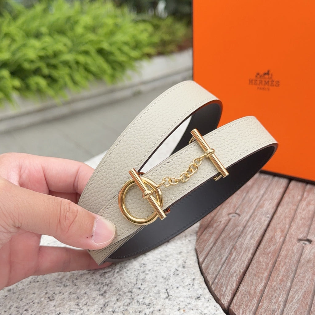 Leather belt on hand, light strap with gold buckle, chain detail, dark underside