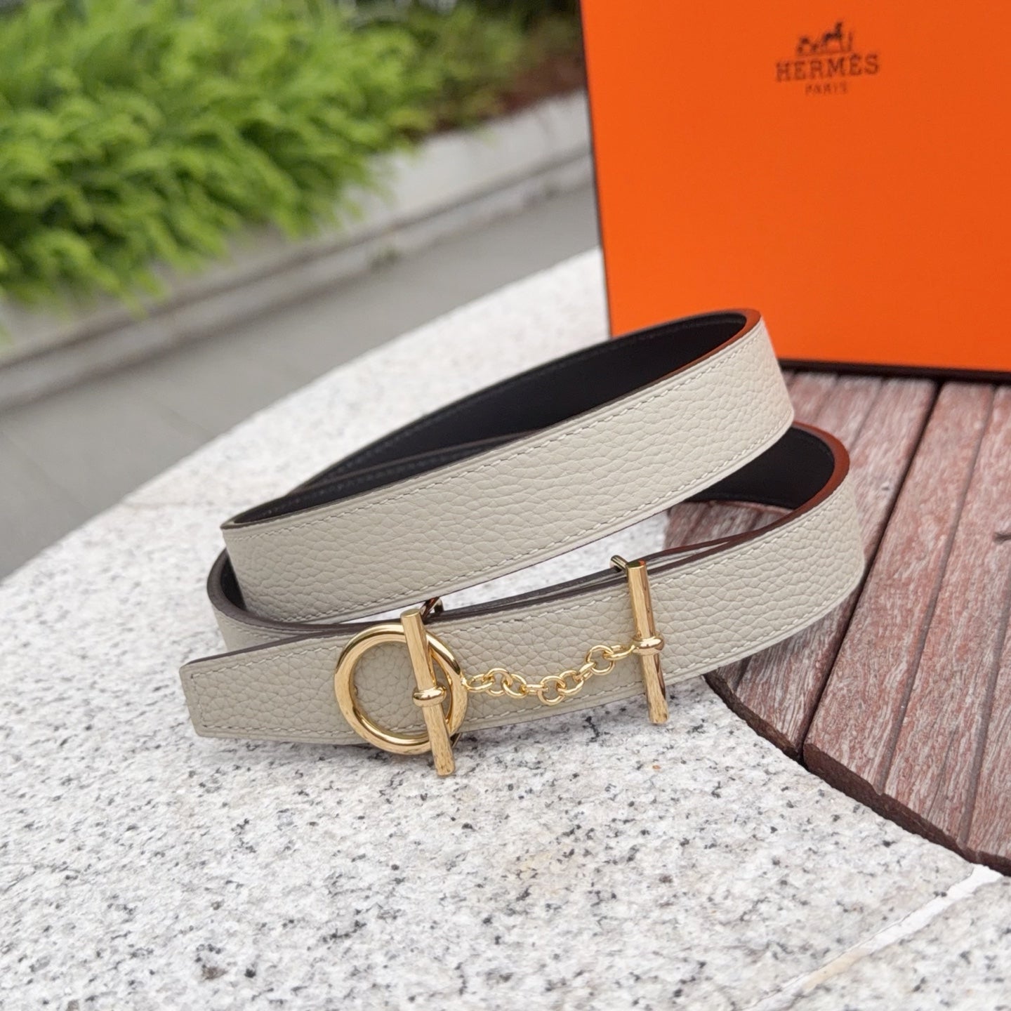 Leather belt with light strap and gold buckle, chain detail, viewed from side