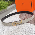 Leather belt with light textured strap, gold buckle and chain detail, black edge