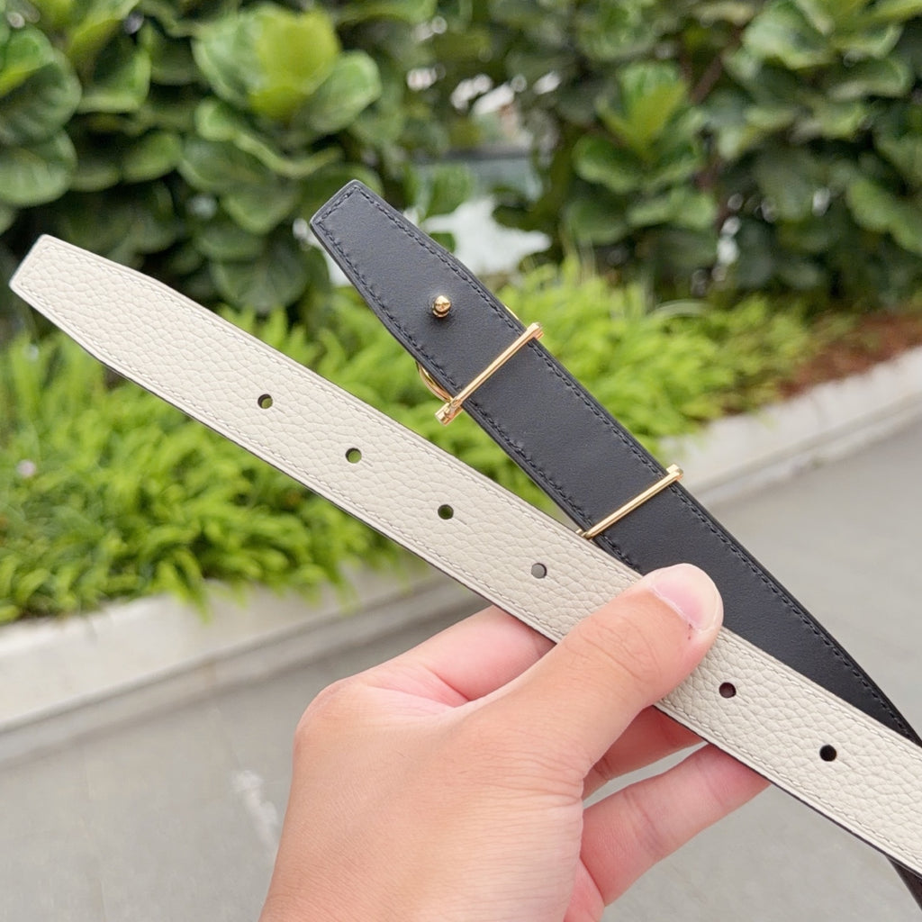 Hermes belt straps in cream and dark, each with gold-tone buckle