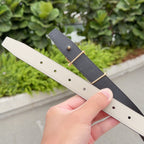 Hermes belt straps in cream and dark, each with gold-tone buckle