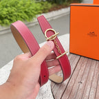 Red leather belt end with gold O-ring buckle and chain link, tan underside, stitched trim