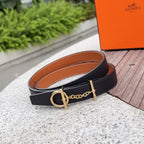 Black leather belt with tan underside, gold-tone buckle and chain detail