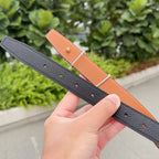 Hermes belt in dark leather with tan underside and punched adjustment holes
