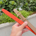 Hermes belt showing tan strap with gold ring buckle and bright orange underside