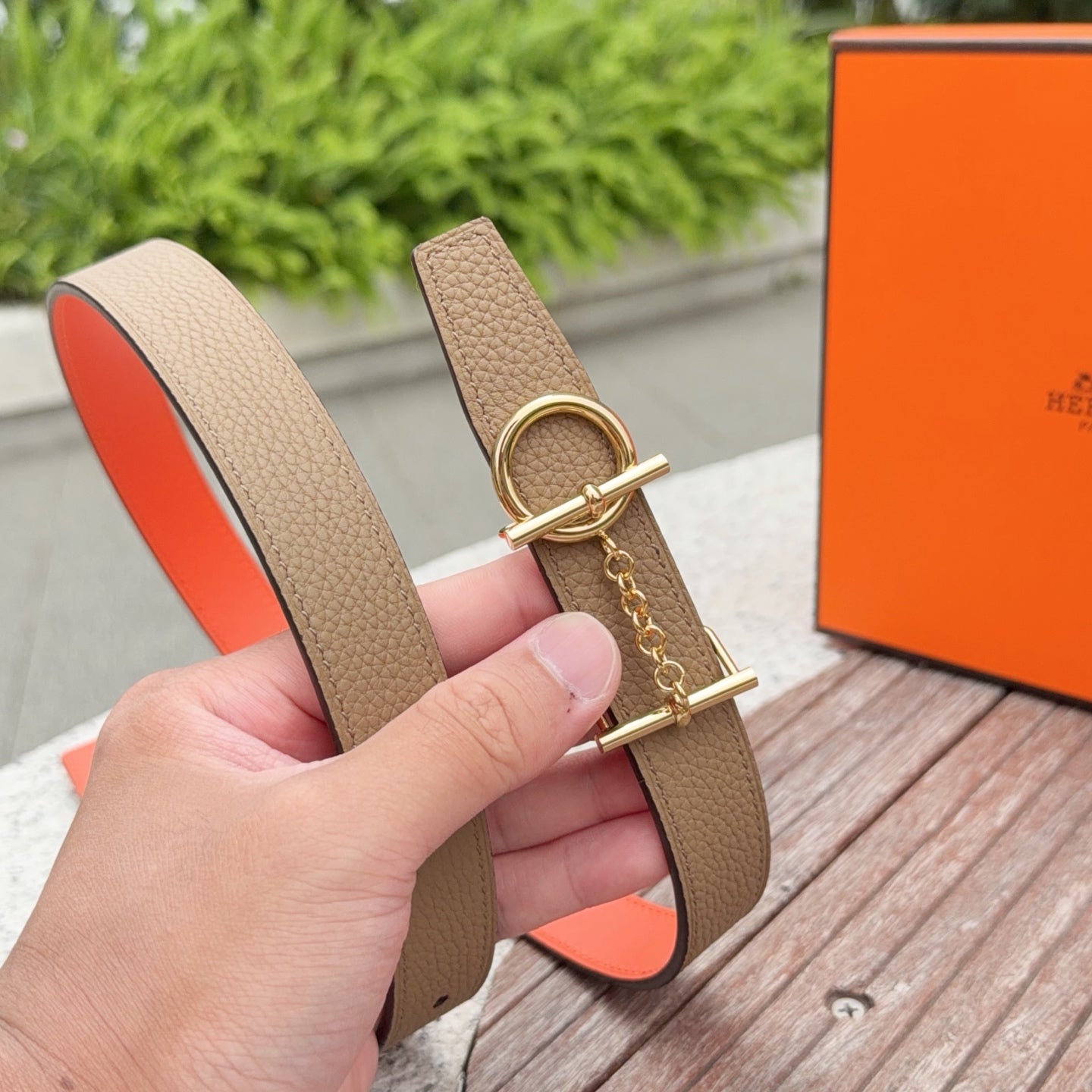 Hermes leather belt with tan strap, gold buckle, and red interior edge