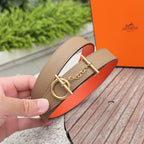Hermes leather belt detail: tan strap with gold buckle and chain accent