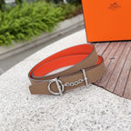 Tan Hermes belt with silver buckle and chain; orange underside visible