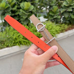 Hermes leather belt with tan and bright orange straps, punched holes and silver rings