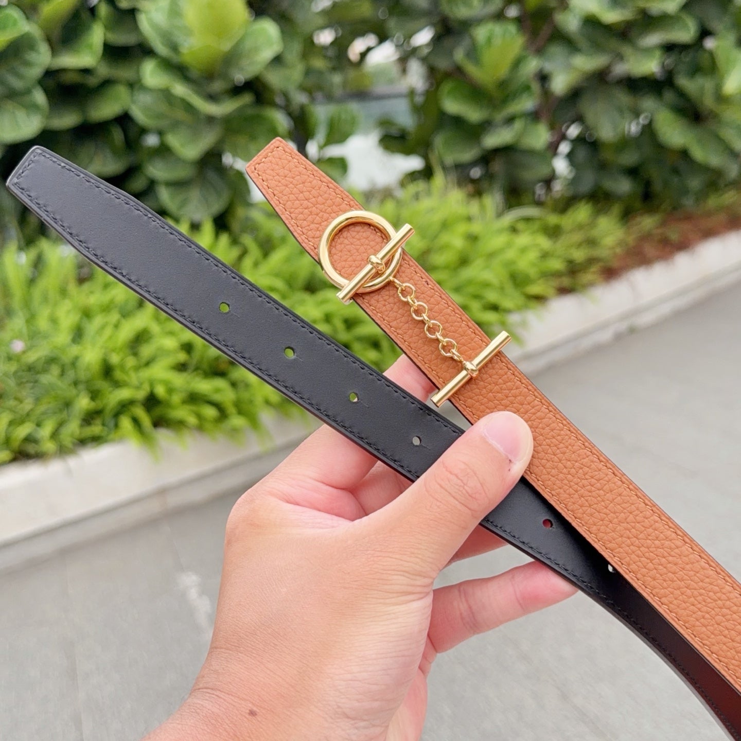 Orange leather belt and dark leather belt with gold chain and buckle hardware