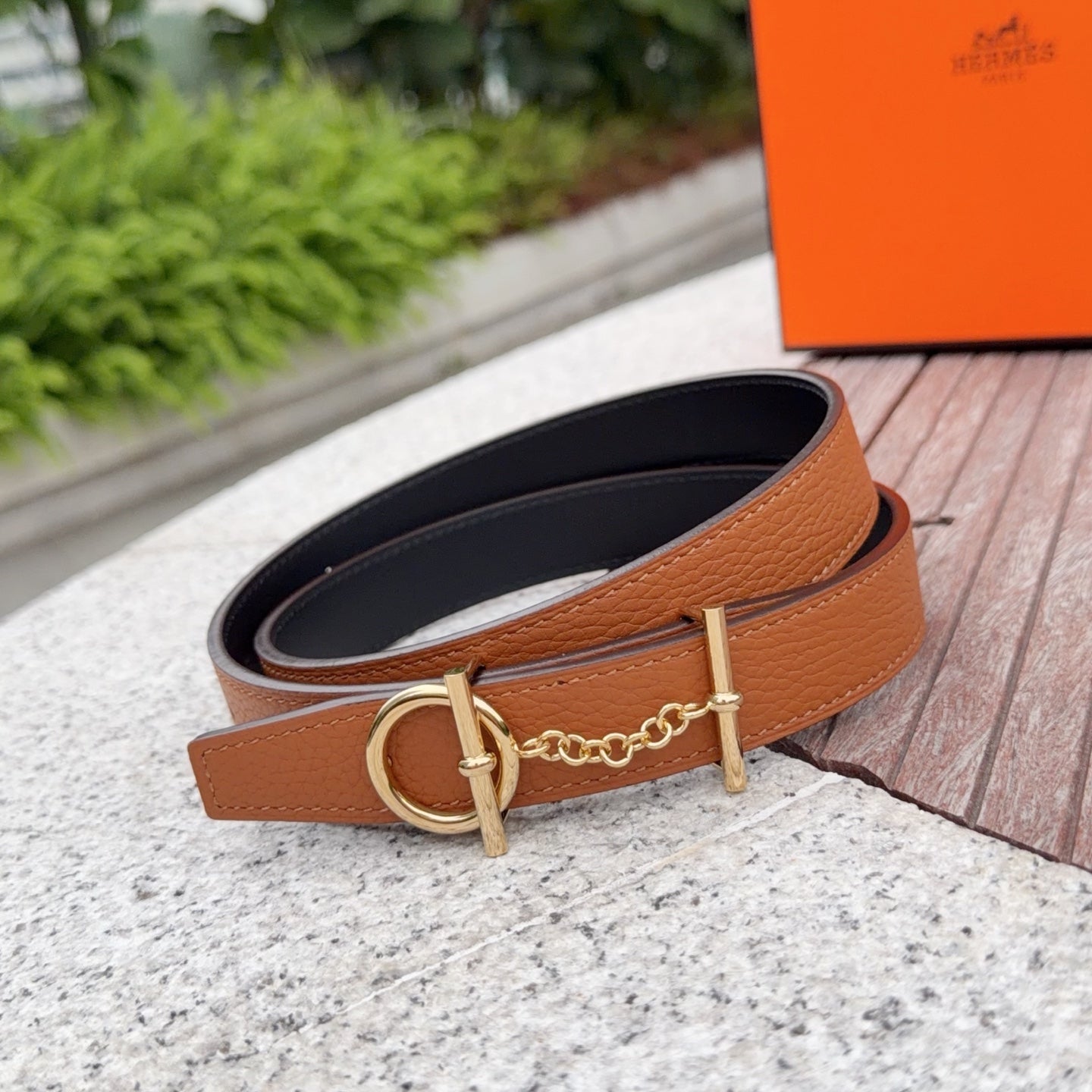 Brown leather belt with gold buckle and chain, black-lined underside