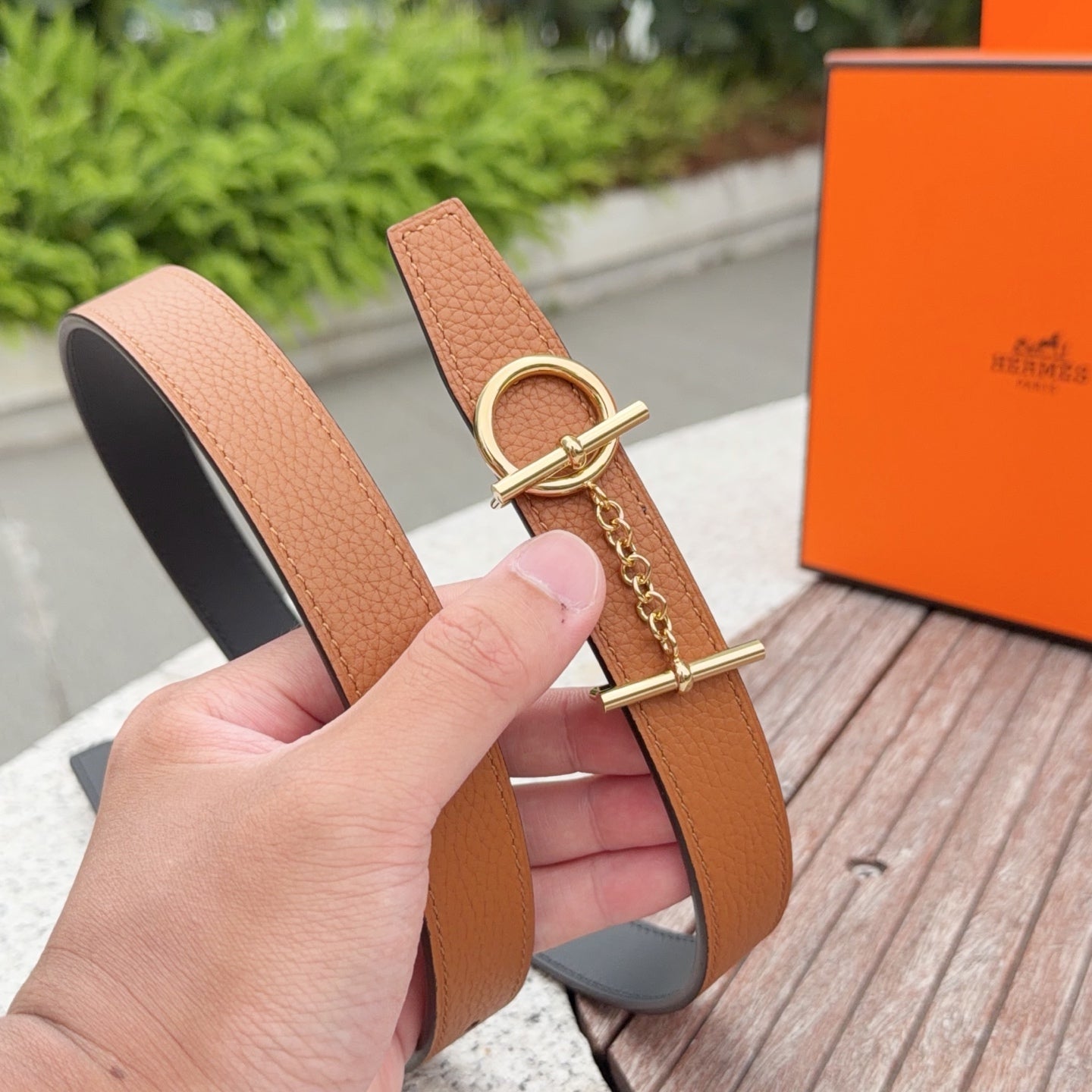 Tan leather belt with gold ring buckle and chain, front view