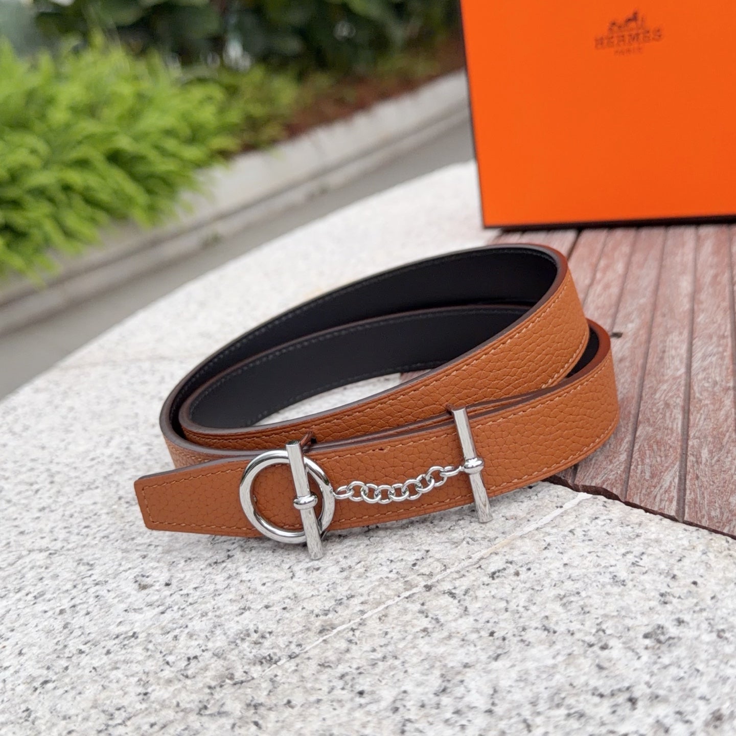 Hermes leather belt with tan top and dark underside, silver buckle ring and chain